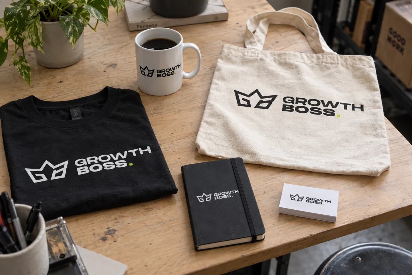 A mug, t-shirt, tote bag, notebook and business cards printed with the Growth Boss logo